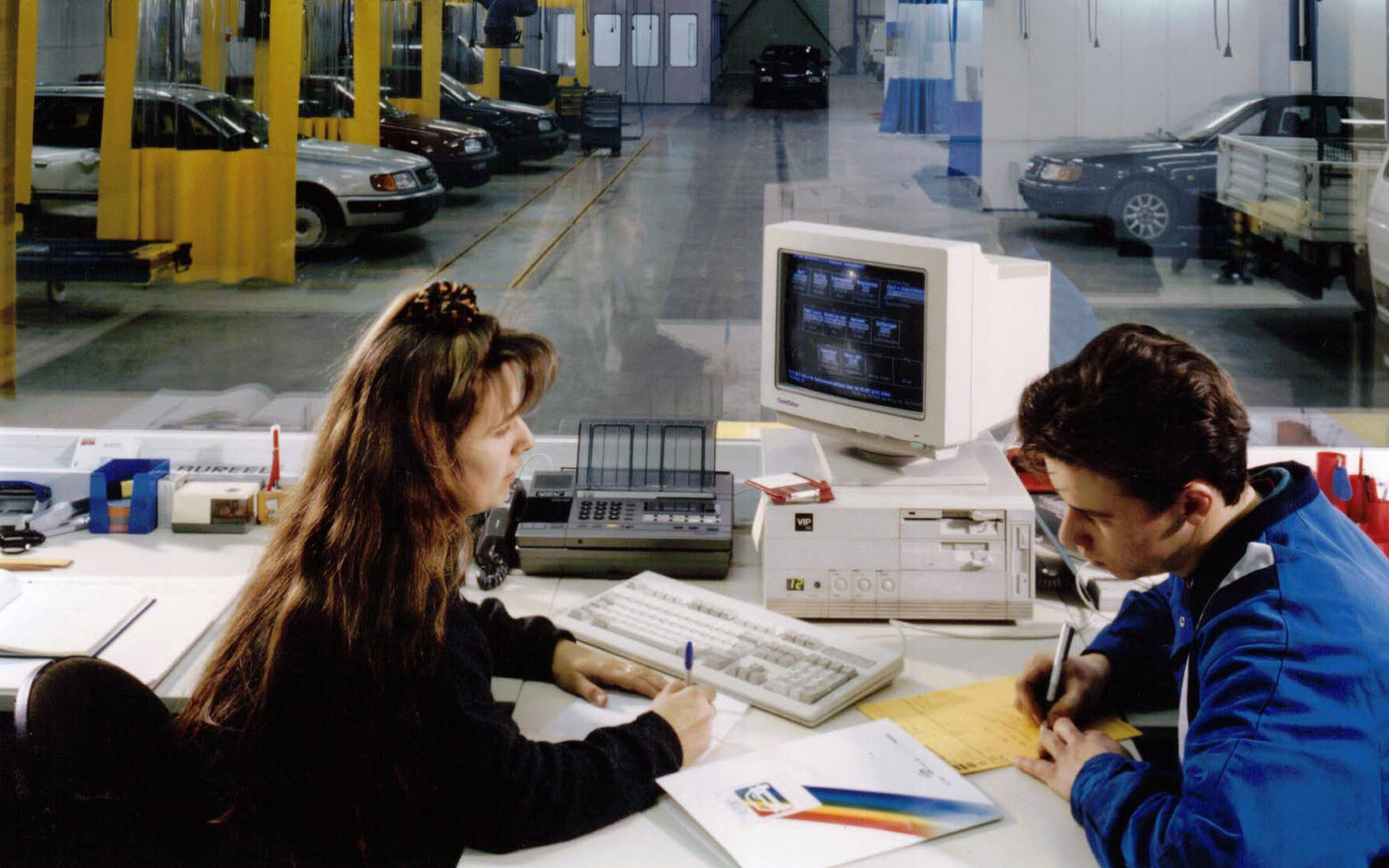 Wonitrol in de jaren '90 — Kristien en een collega aan het werk in het bureau, met de werkplaats op de achtergrond.